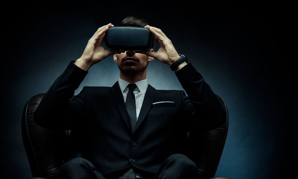 mężczyzna w garniturze siedzi na fotelu i zakłada google VR by obejrzeć wirtualny spacer